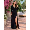 Vestido negro largo elegante con escote cruzado, manga larga y abertura lateral en la pierna.
